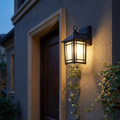 LED outdoor wall lamp mounted on a stucco villa entrance wall at dusk